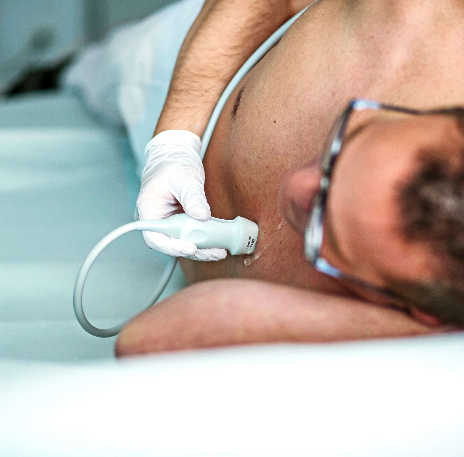 Arzt führt Ultraschall bei einem männlichen Patienten durch